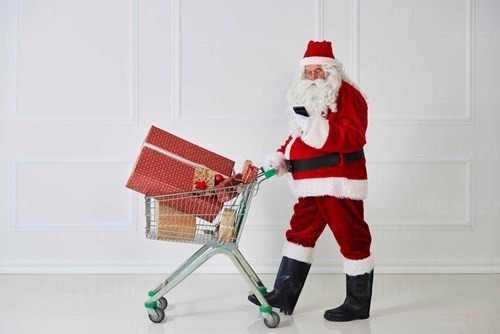 santa-claus-carrying-christmas-presents-in-a-shopping-cart-while-looking-at-cell-phone-abif00108.jpeg